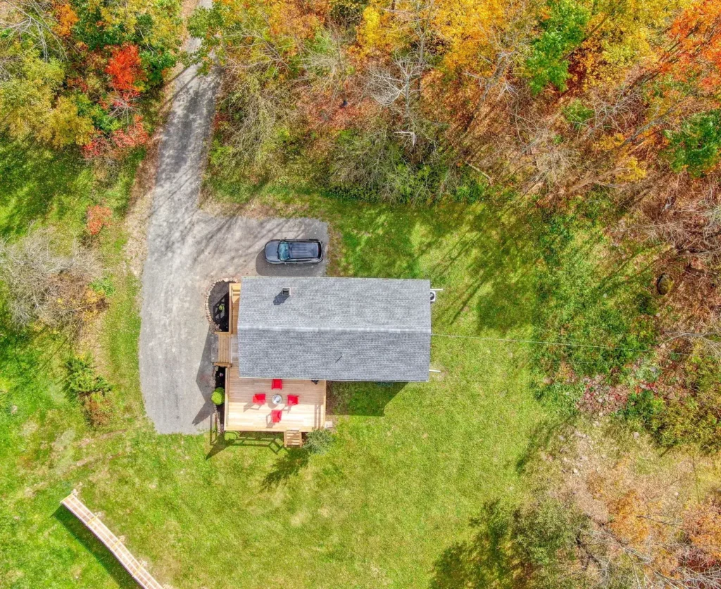Aerial view of Clove Creek Cabin and its deck among fall trees in Hunter, NY