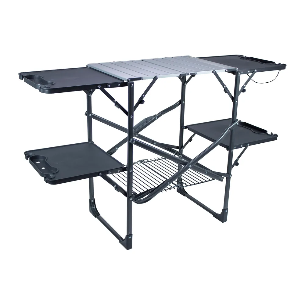 GCI Outdoor Slim-Fold Cook Station, set up with aluminum tabletop, four side tables and lower rack, three-quarter view