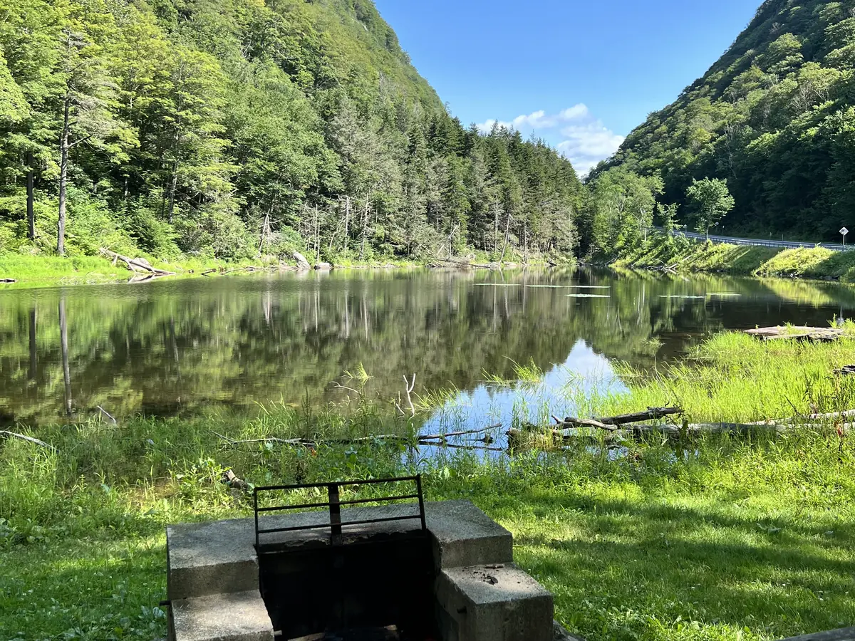 Notch Lake on Route 214 in Stony Clove Notch, with a stone dam and steep green slopes on both sides